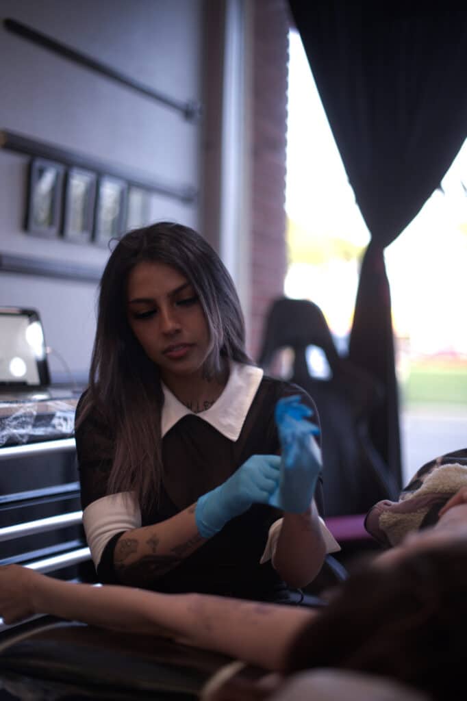 Vlogigurl tattooing at a shop in California.