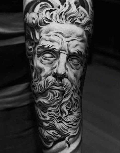 Black and gray tattoo of Zeus's face. Zeus is made of marble or stone and the tattoo is very realistic. 