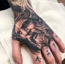 Black and gray tattoo on a hand.