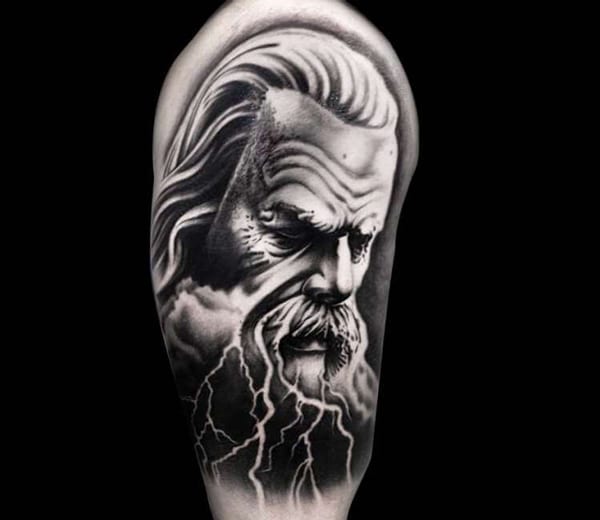 Black and white Zeus tattoo where he looks sad and has lightning tears. 