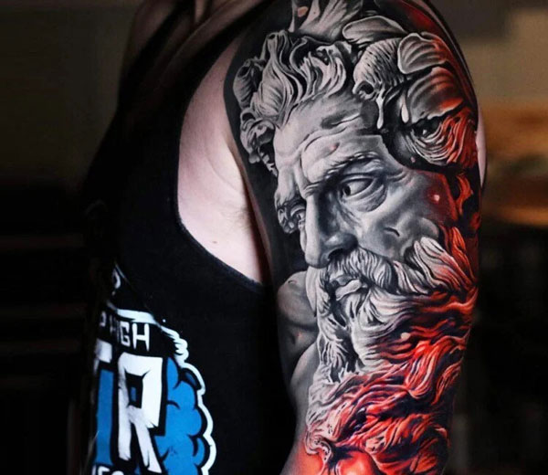 Black and gray Zeus tattoo with red highlights.